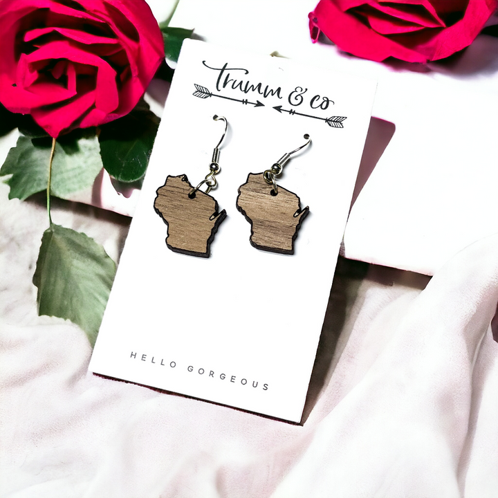 Walnut Wisconsin silhouette dangle earrings on a white fabric with red roses