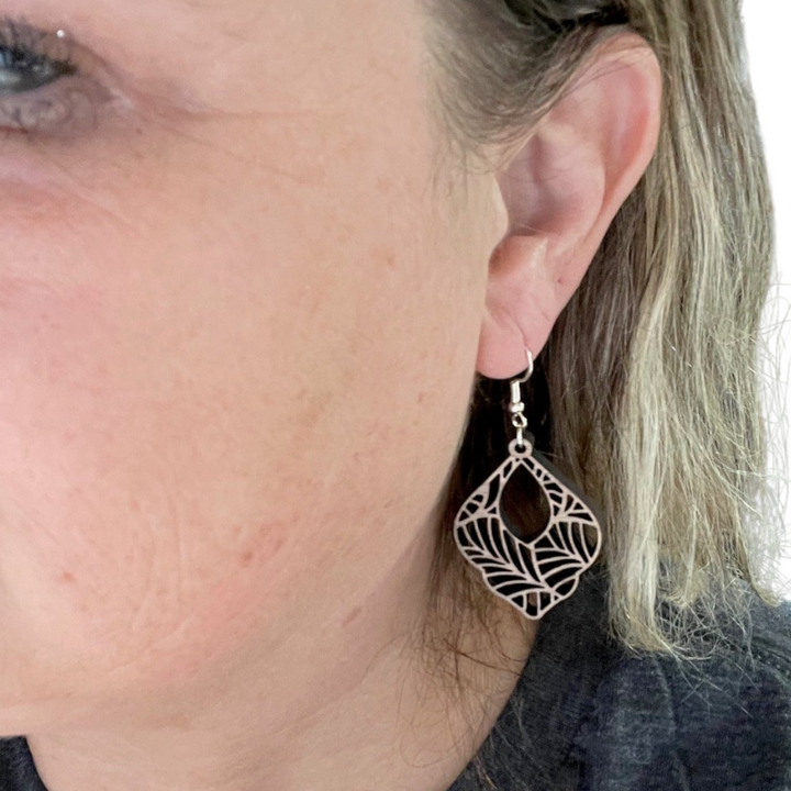 Photo of owner wearing Boho laser cut wood dangle earring from Trumm and Co