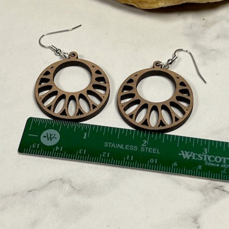Pair of walnut circle burst earrings shown above ruler for size