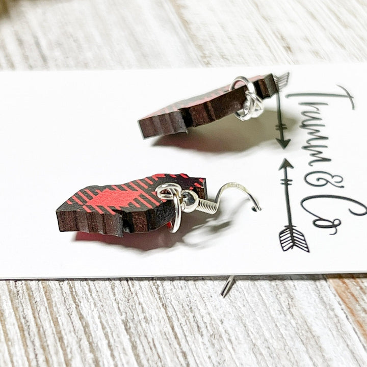 Close up photo of Wisconsin state shape earrings in red and black plaid laying on white earring card by Trumm & Co