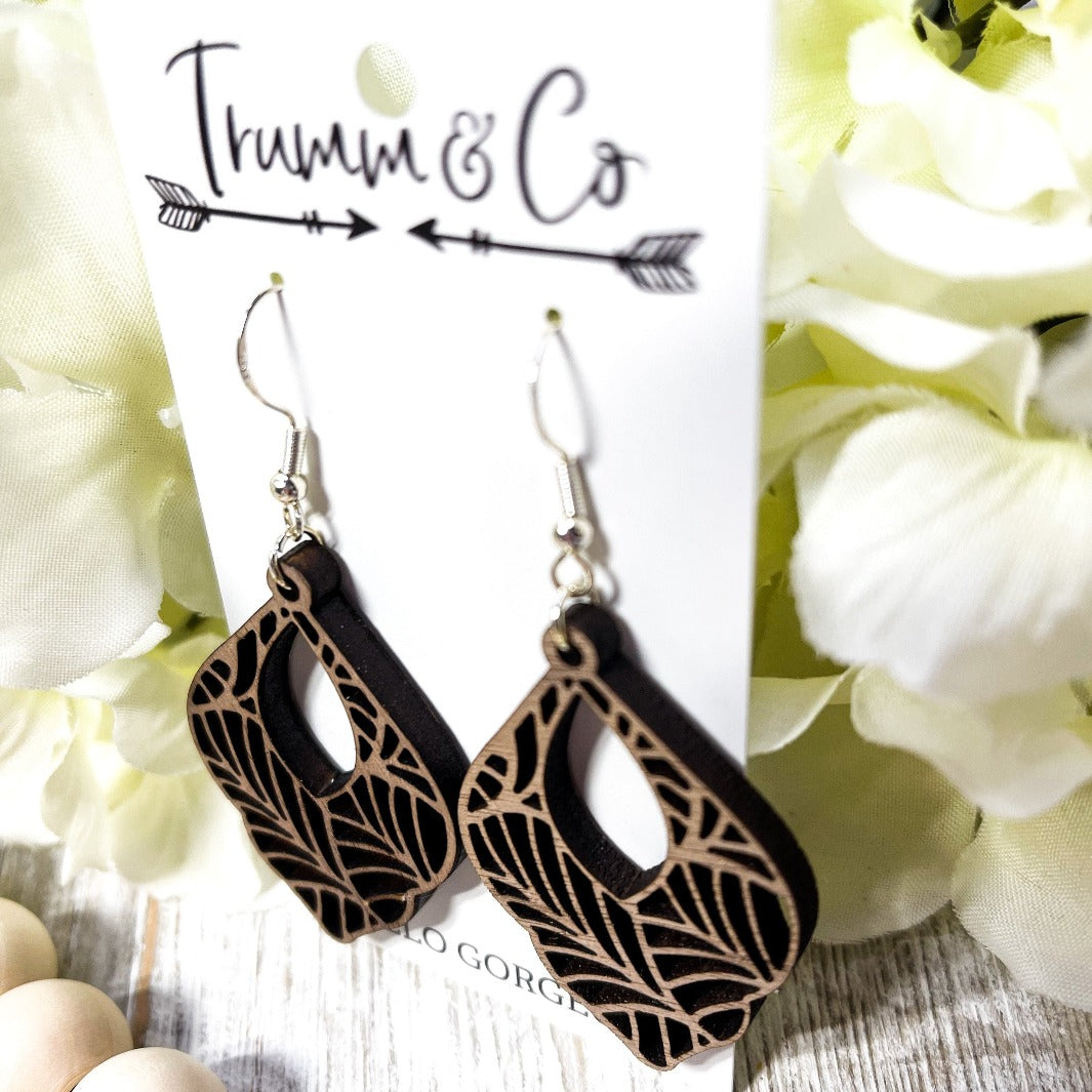 Bright photo showing off Boho Walnut wood dangle laser cut earrings from Trumm and Co