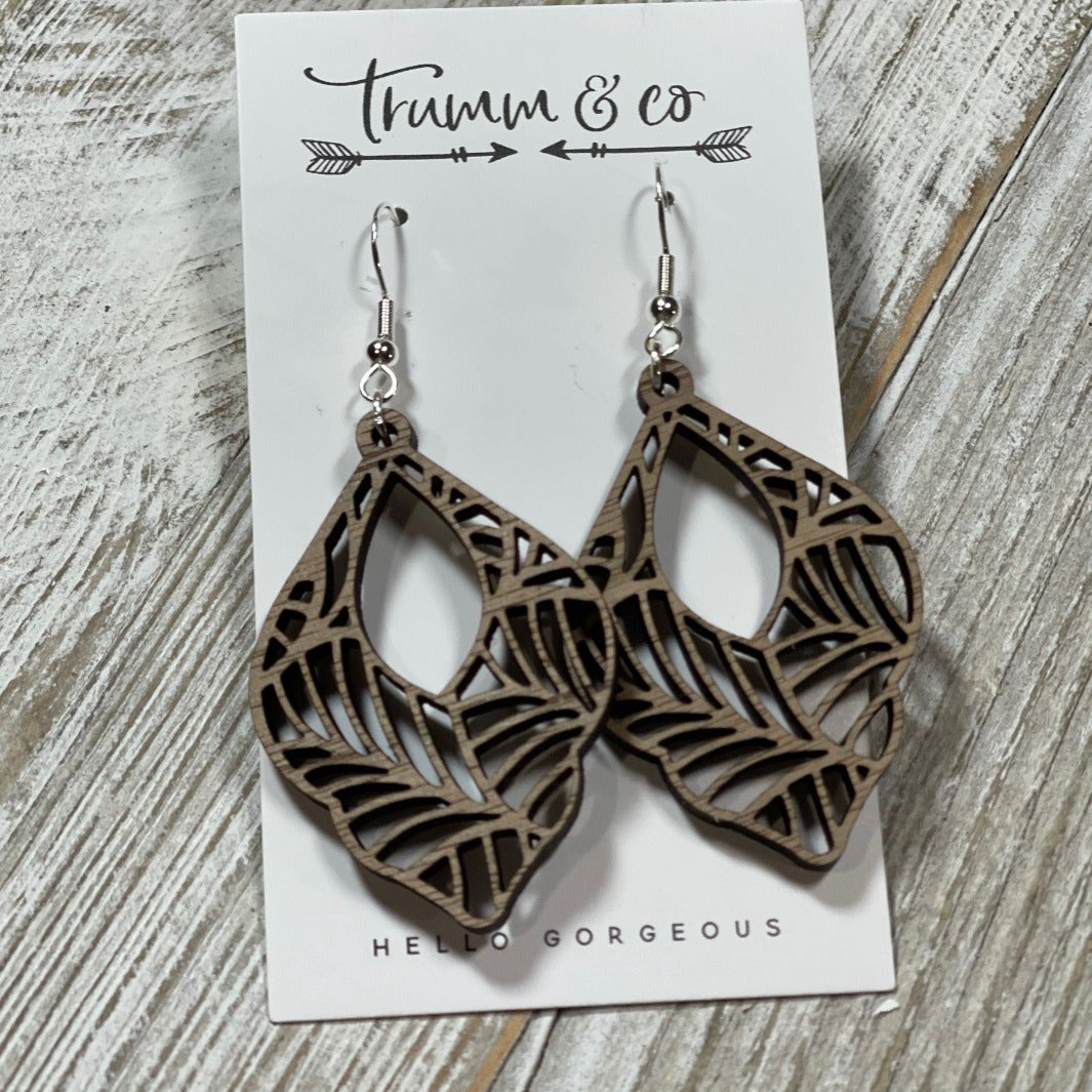 Bright photo showing off Boho Walnut wood dangle laser cut earrings from Trumm and Co